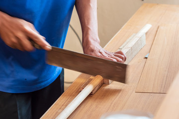 The mechanic is using a saw