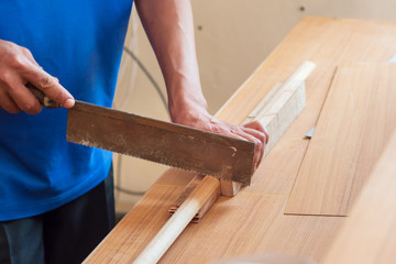 The mechanic is using a saw