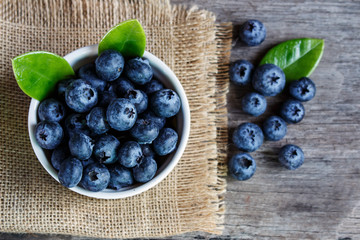 Blueberries in a white bowl on a wooden table
