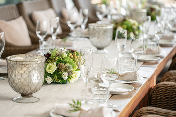 Wedding Banquet or gala dinner. The chairs and table for guests, served with cutlery and crockery. Covered with a linen tablecloth runner. party on terrace