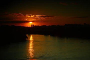 Very dark sunset over the river in the city