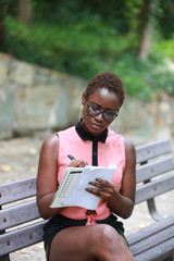 Fototapeta premium Stylish black woman writing with concentration