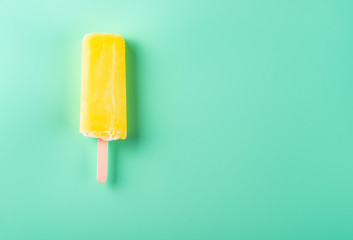 yellow popsicle on a light green background