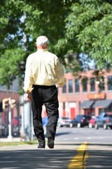 Fototapeta premium Senior Balding Male Walking On Sidewalk