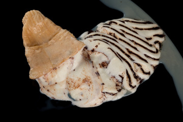 top view ice cream cone melting completely on black background