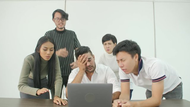 Casual creative business team getting very bad news on his laptop computer screen and feeling disappoint.