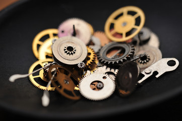 Detail of watch machinery in spoon on the brown wood background.