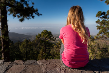 Junges blondes Mädchen genießt den Ausblick auf einem Berg