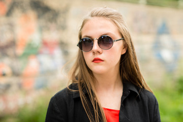 beautiful girl with long hair in sunglasses with bag in long dark clothes