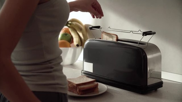 Breakfast. Woman Putting Slicing Bread In Toaster Closeup