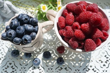 fresh blueberries and raspberries on a wooden tray
