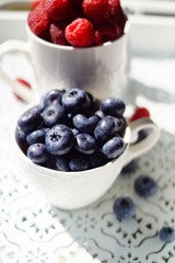 fresh blueberries and raspberries on a wooden tray
