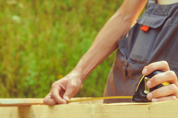 the worker makes measurements with a tape measure