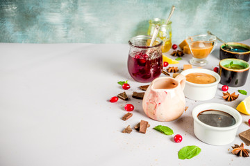 Various sweet sauces, toppings and syrups - lemon, orange, caramel, chocolate, cranberry, cherry, blueberry, on a light concrete background, top view copy space for text