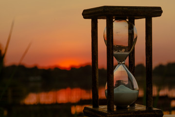 hourglass counts down the time on the sunset pond
