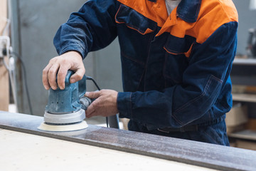 Furniture production or craft concept: worker polishing the stone surface of furniture part with...