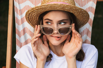 Cute young girl in sunglasses resting on a hammock