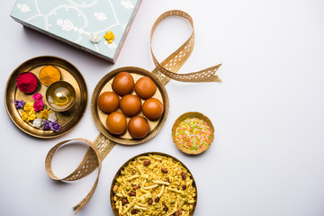Raksha bandhan Festival : conceptual Rakhi made using plate full of Gulab Jamun sweet with band and Pooja Thali. A traditional Indian wrist band which is a symbol of love between Brothers and Sisters