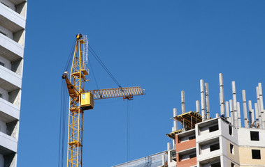 Construction of a multi-storey buildings. Construction crane in sky background.