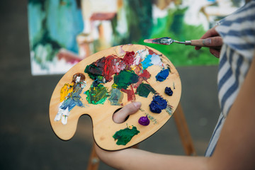 Palette with paints and spatula. Drawing a picture.