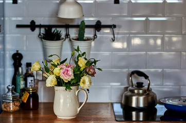 Rustic kitchen decor:  vintage  kitchenware and porcelain white vase with a beautiful  flowers. Vintage style.