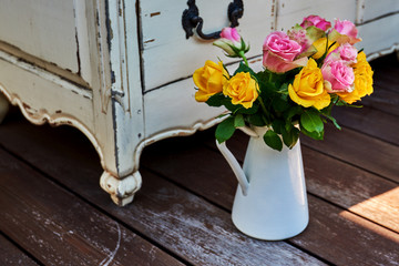Beautiful bouquet of  roses on the background vintage furniture.