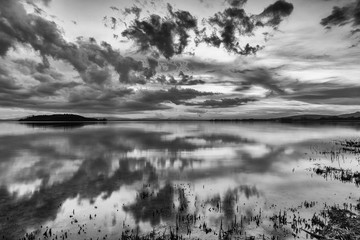 Fototapeta premium Perfect and symmetric clouds and islands reflections on a lake, making abstract shapes