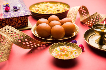 Raksha bandhan Festival : conceptual Rakhi made using plate full of Gulab Jamun sweet with band and Pooja Thali. A traditional Indian wrist band which is a symbol of love between Brothers and Sisters