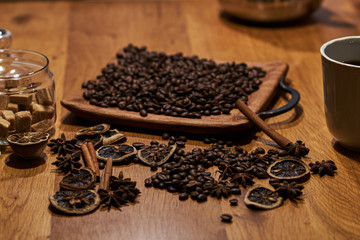 Coffee beans, sugar cubes and cinnamon on dark brown table.