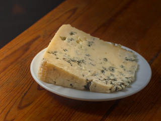 Plate with cheese on a wooden table
