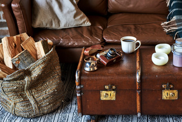 Cup of coffee in morning with old camera in vintage style interior. Image of retro camera and vary of decoration on wooden table background. Vintage color tone.