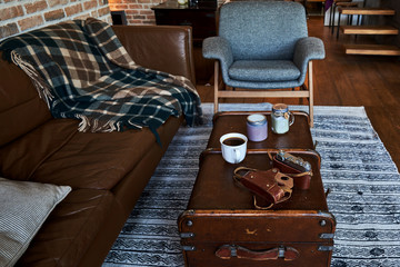Cozy living room with leather sofa and brick wall. Vintage style interior background.