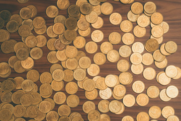 Stack of coin on wooden working table, business and finance concept.