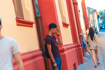 Young man standing on the street waiting for friends.