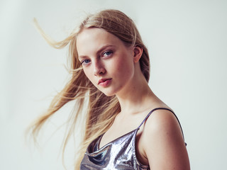 Obraz premium Blonde long hair woman girl in silver dress over white background