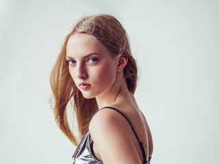 Naklejka premium Blonde long hair woman girl in silver dress over white background