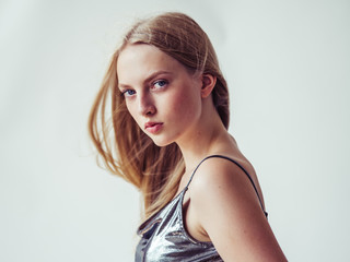 Fototapeta premium Blonde long hair woman girl in silver dress over white background