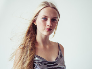 Fototapeta premium Blonde long hair woman girl in silver dress over white background