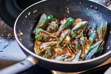 Boiled mussels in pan cooking close up