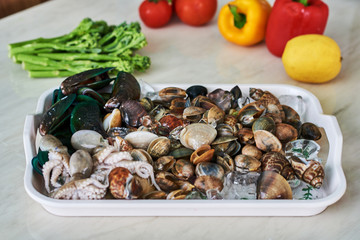 raw mussels and vegetables in the kitchen