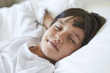 Fototapeta na wymiar Resting boy asleep in bed, close up