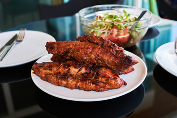 Grilled beef steak with salt and pepper on  a black desk.