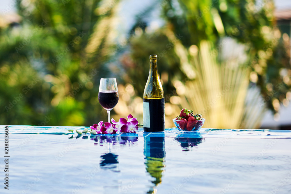 Wall mural Wine party in the pool.  Wine glasses and bottle.