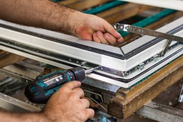 Production of pvc windows, a man screws a screwdriver into a pvc window, close-up, windows pvc