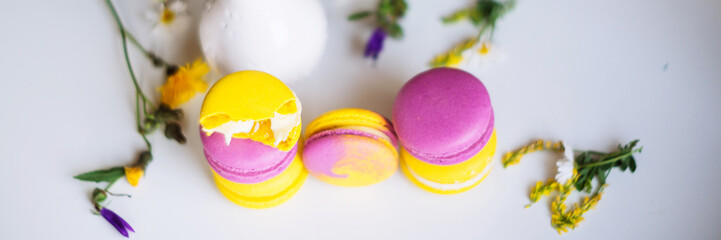 Macaroons and pink flowers tulips on white rustic wooden table with place for text. Present on Mothers day, Valentines Day or Womens day. Gritings woman concept. Copy space.