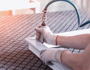 Production of pvc windows, stripping corners in a pvc frame, close-up, sweeping