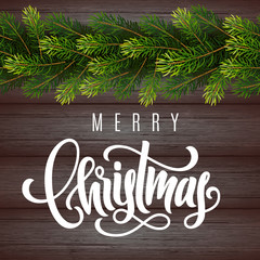 Holiday gift card with hand lettering Merry Christmas and fir tree branches on wood background. Template for a banner, poster, invitation