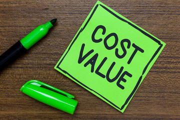 Conceptual hand writing showing Cost Value. Business photo showcasing The amount that usualy paid for a item you buy or hiring a person Green Paper Communicate ideas Marker Wooden background.