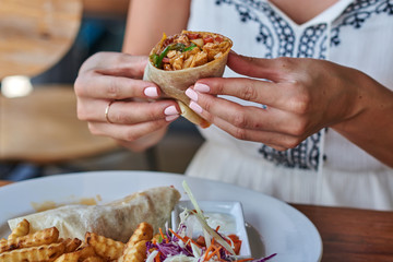Close up of a female hand holding Chinese spring rolls..
