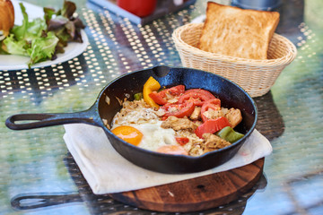 Breakfast  fried eggs, bread and fresh vegetables.